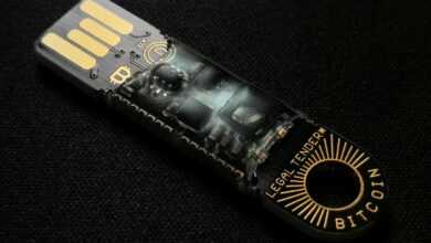 A detailed close-up of a Bitcoin-themed USB device on a black background.