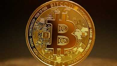 a golden bitcoin sitting on top of a table