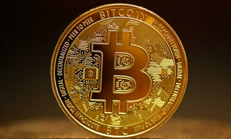 a golden bitcoin sitting on top of a table