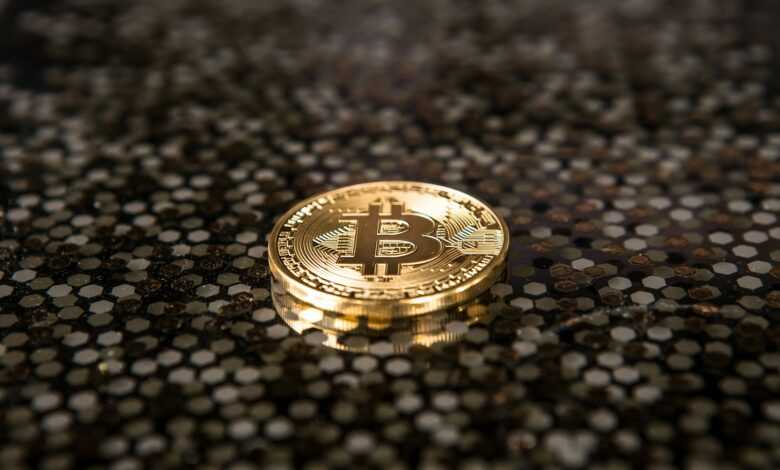 gold-colored Bitcoin coin on ground