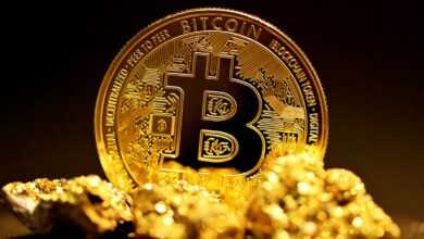 a bitcoin sitting on top of a pile of gold nuggets