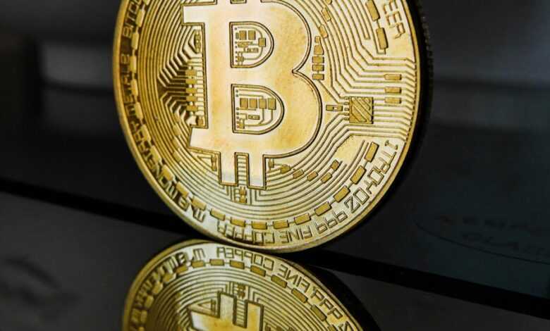 a golden bit coin sitting on top of a table